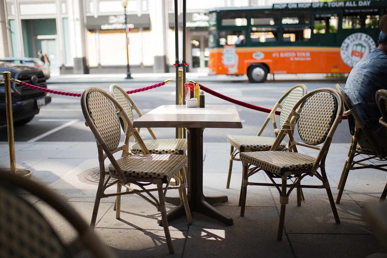 Wicker bistro chairs around a table on a sidewalk patio