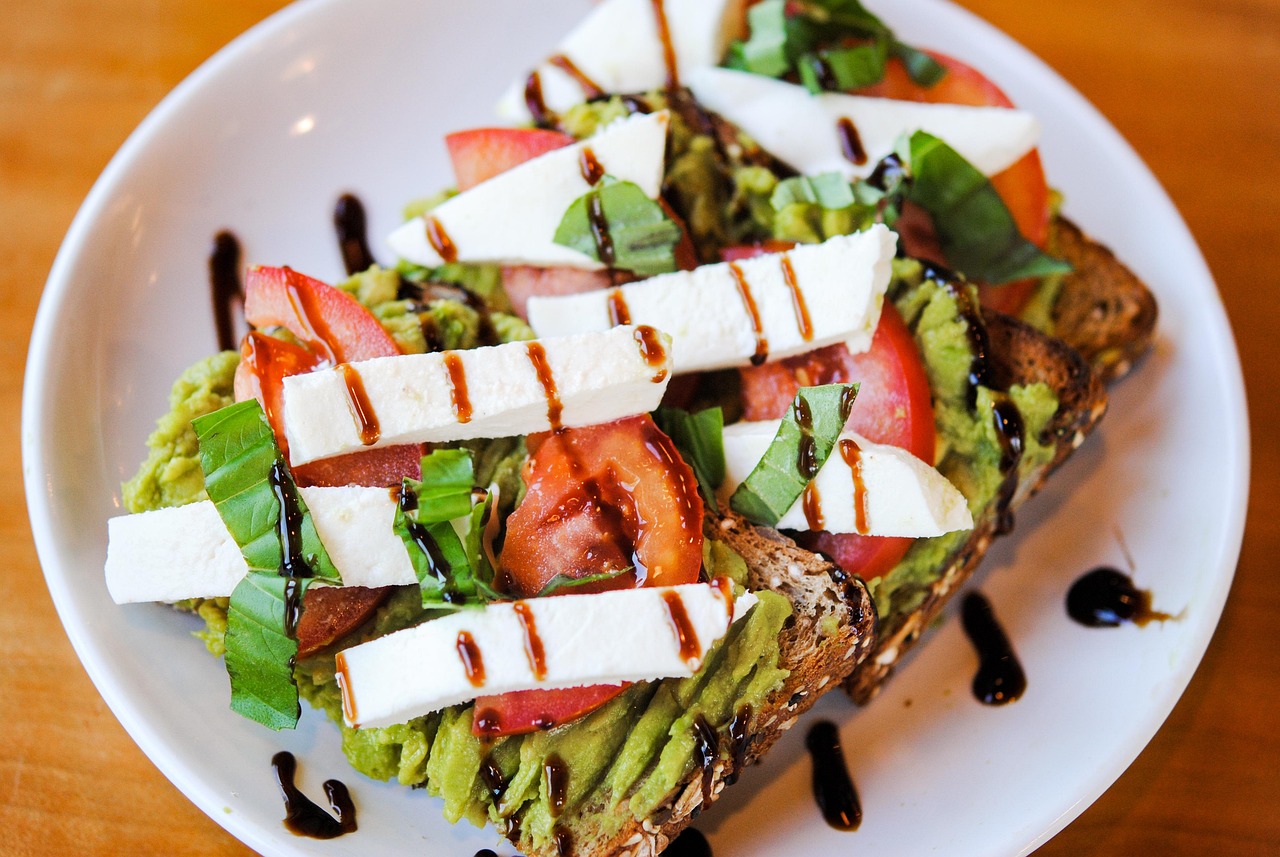 Avocado toast topped with tomato, basil and balsamic